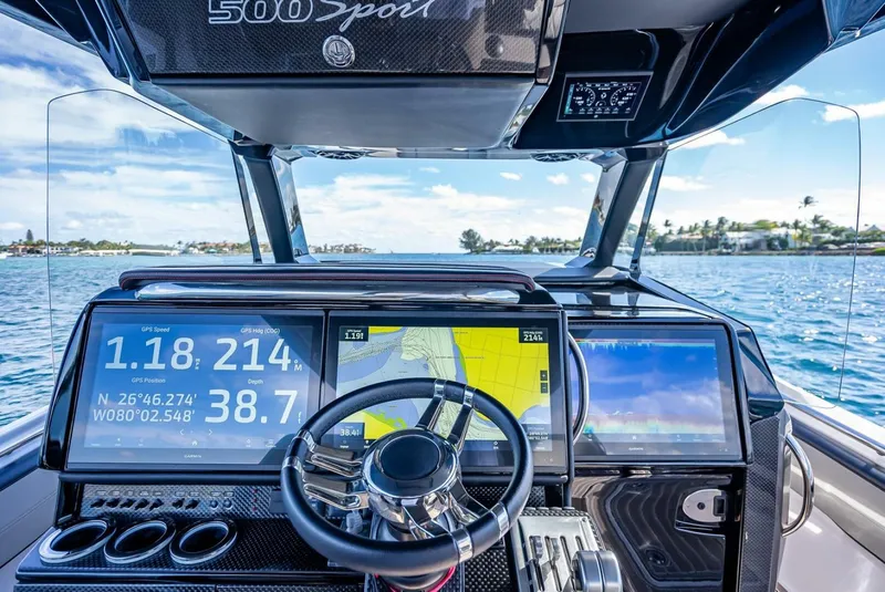 Slide: The Image of 2023 Nor-Tech 500 Sport boat dashboard with advanced navigation displays on open water. - 16