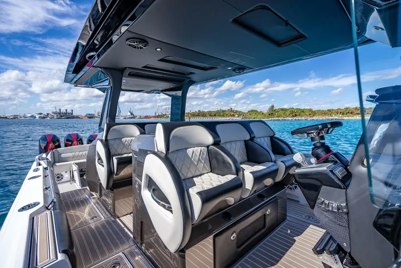 Slide: The Image of 2023 Nor-Tech 500 Sport boat interior with luxurious seating and modern helm, on a sunny day. - 19