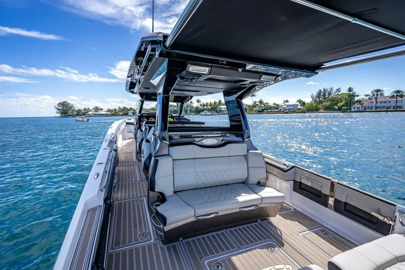 Slide: The Image of 2023 Nor-Tech 500 Sport boat interior with luxurious seating on a sunny day. - 28