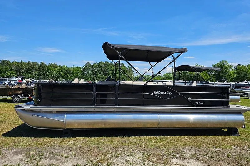 Slide: The Image of 2026 Bentley Pontoons Fish 240 4-Point pontoon boat on grassy area under blue sky. - 7