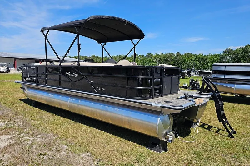 Slide: The Image of 2026 Bentley Pontoons Fish 240 4-Point pontoon boat on grassy area under blue sky. - 8