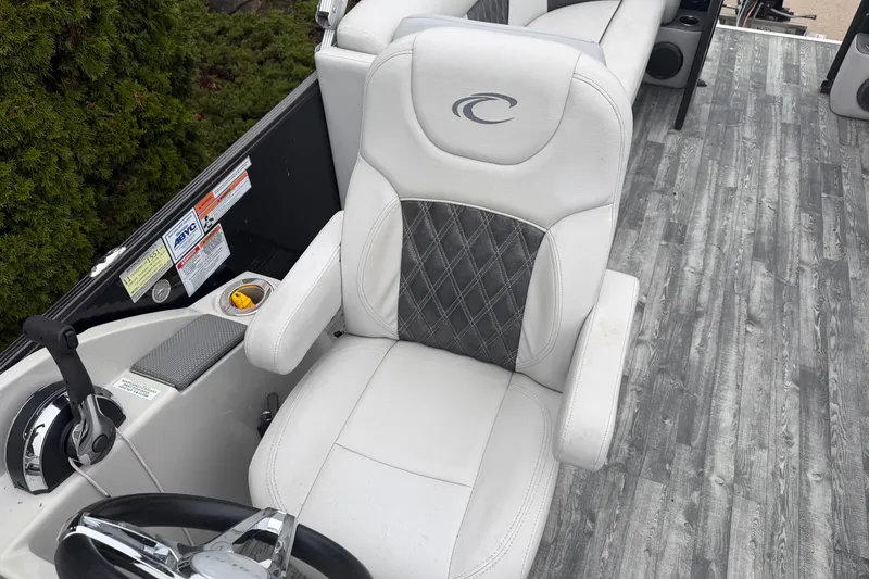 Slide: The Image of 2019 Crest II SLC LTD boat interior with white captain's chair and wood-patterned flooring. - 10