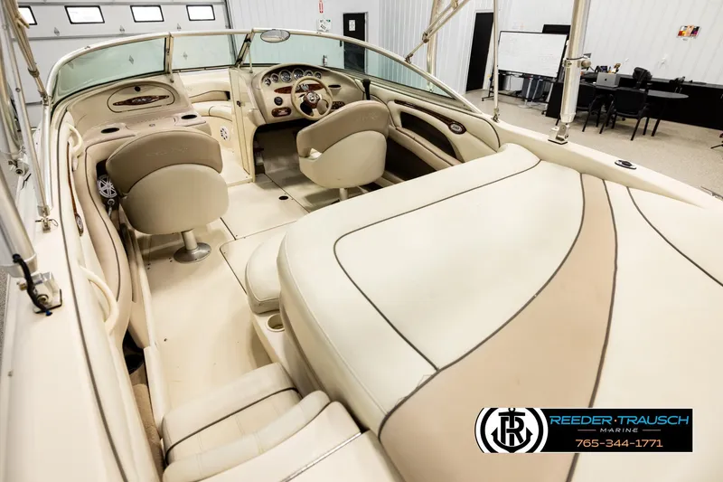 Slide: The Image of Interior view of a 2003 Sea Ray 200 Bow Rider boat, featuring beige seating and dashboard. - 10