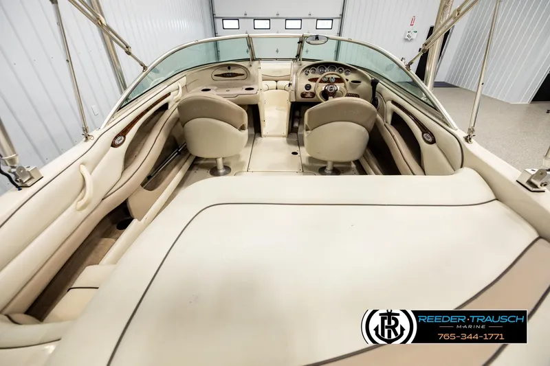 Slide: The Image of Interior view of 2003 Sea Ray 200 Bow Rider boat, featuring beige seating and dashboard. - 12