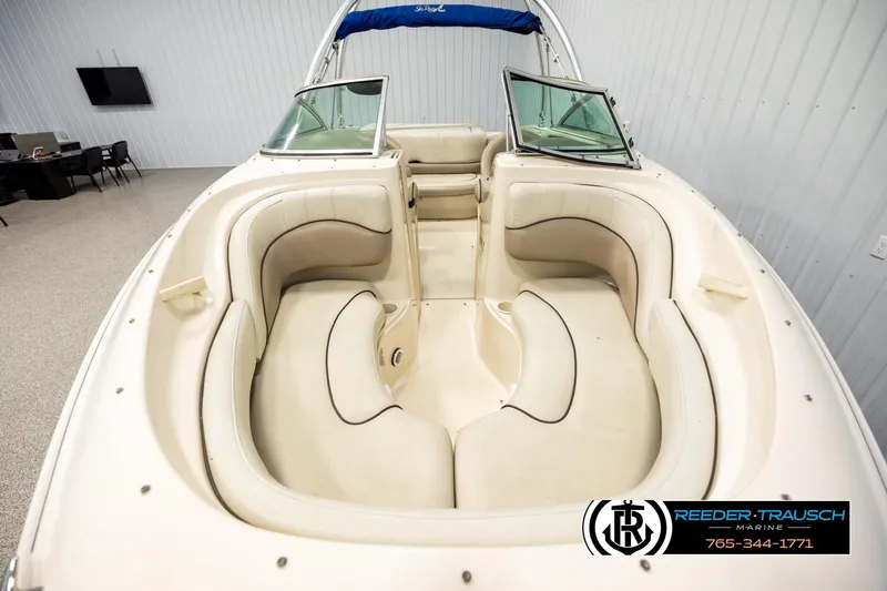 Slide: The Image of 2003 Sea Ray 200 Bow Rider interior with beige seating and open windshield. - 15