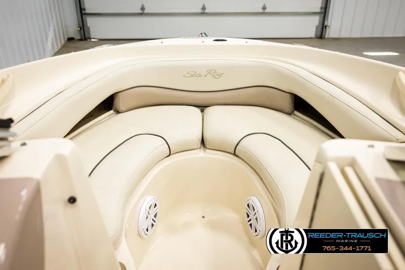 Slide: The Image of 2003 Sea Ray 200 Bow Rider interior with beige seating and speaker, Reeder-Trausch Marine logo. - 18