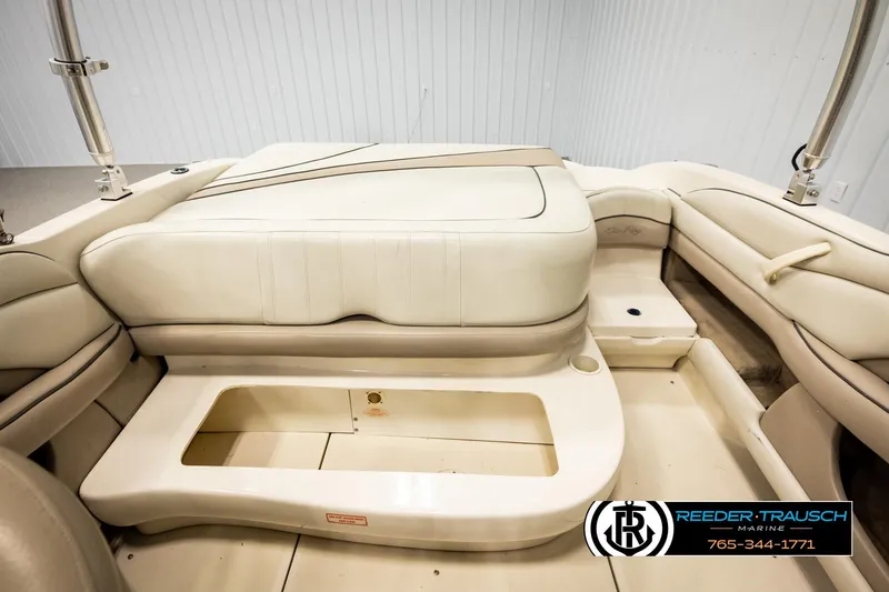 Slide: The Image of Interior of a 2003 Sea Ray 200 Bow Rider boat, featuring beige seating and storage area. - 21