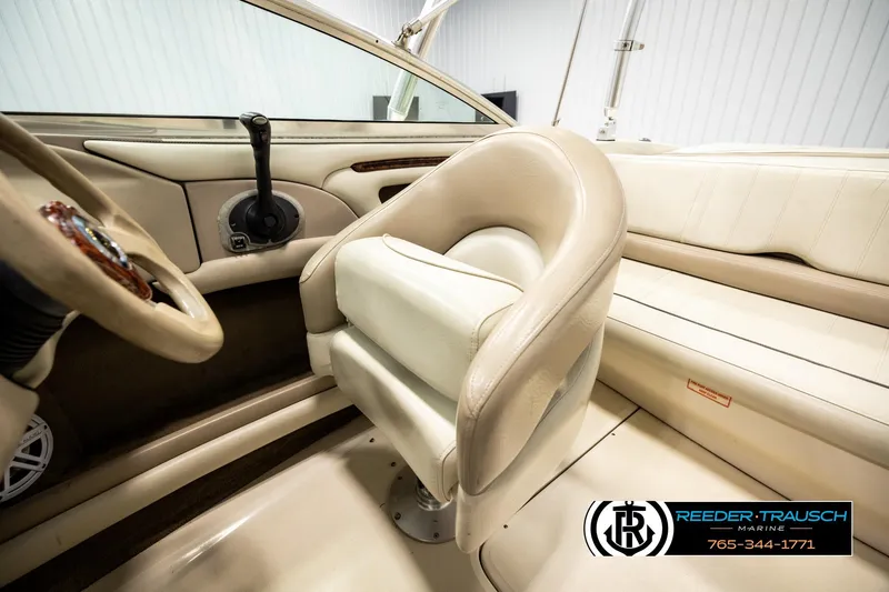 Slide: The Image of Interior of a 2003 Sea Ray 200 Bow Rider boat with beige seating and steering controls. - 26