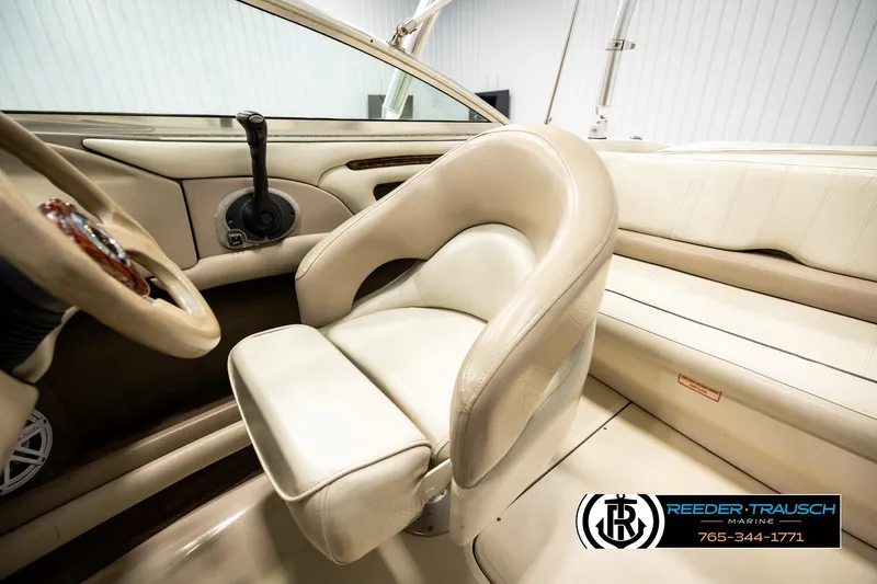 Slide: The Image of Interior of a 2003 Sea Ray 200 Bow Rider boat with beige seating and steering wheel. - 27