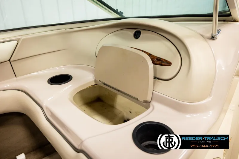 Slide: The Image of 2003 Sea Ray 200 Bow Rider interior with storage compartment and cup holders. - 29