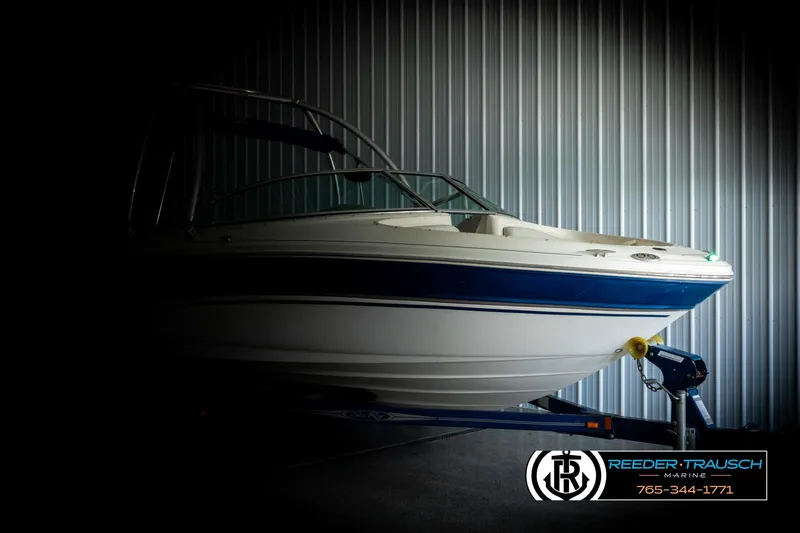 Slide: The Image of 2003 Sea Ray 200 Bow Rider boat in storage, side view with blue accents. - 3
