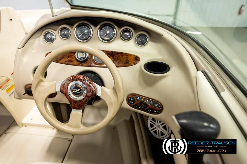 Slide: The Image of 2003 Sea Ray 200 Bow Rider dashboard with wood accents and steering wheel. - 33