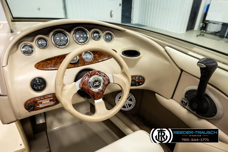 Slide: The Image of Interior view of a 2003 Sea Ray 200 Bow Rider boat dashboard with steering wheel and controls. - 34