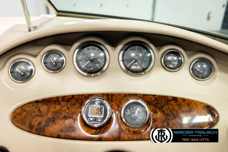 Slide: The Image of Dashboard of a 2003 Sea Ray 200 Bow Rider boat with gauges and wood paneling. - 37