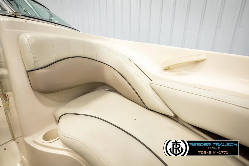 Slide: The Image of 2003 Sea Ray 200 Bow Rider interior seating with beige upholstery and cup holder. - 45