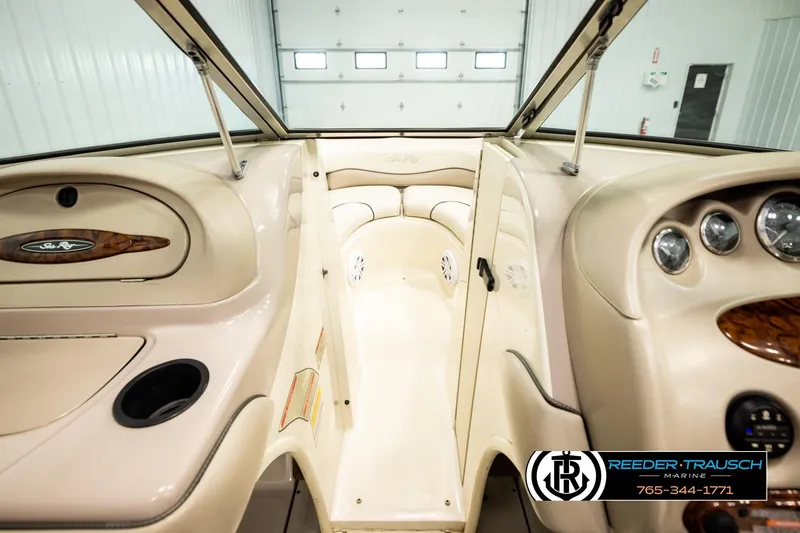 Slide: The Image of Interior view of a 2003 Sea Ray 200 Bow Rider boat, featuring beige dashboard and seating. - 48