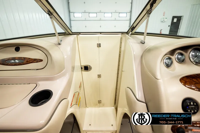 Slide: The Image of 2003 Sea Ray 200 Bow Rider interior dashboard with beige finish and wood accents. - 49