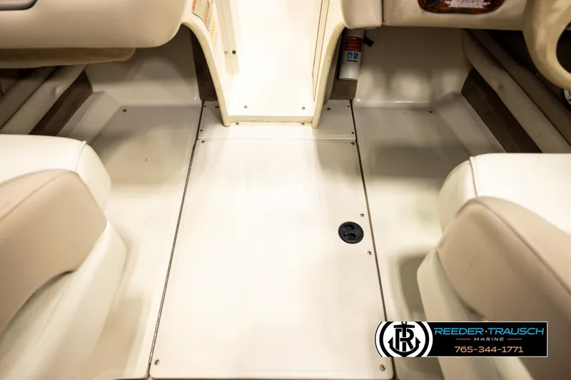 Slide: The Image of Interior of a 2003 Sea Ray 200 Bow Rider boat, featuring beige seating and flooring. - 50
