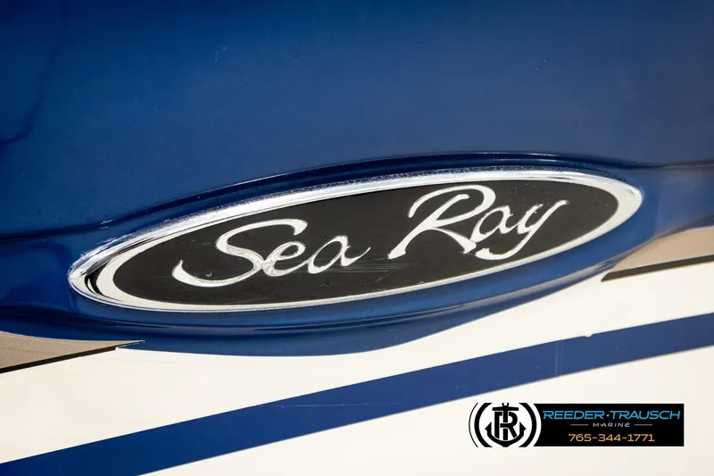 Slide: The Image of Close-up of a 2003 Sea Ray 200 Bow Rider logo on a blue boat. - 59
