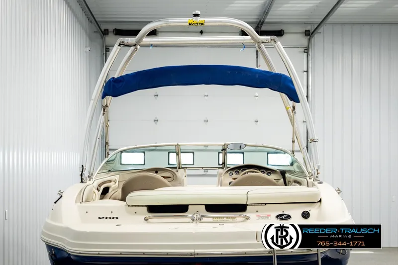 Slide: The Image of 2003 Sea Ray 200 Bow Rider boat in a garage, featuring a blue canopy and sleek design. - 6