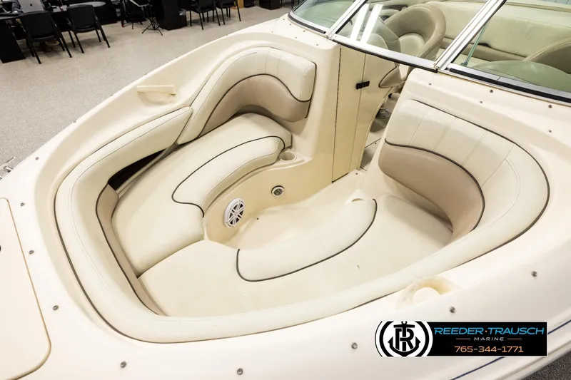 Slide: The Image of 2003 Sea Ray 200 Bow Rider interior with beige seating and windshield, showcased indoors. - 9