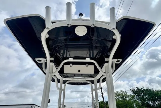 Slide: The Image of 2017 Robalo 246 Cayman boat T-top with rod holders against cloudy sky. - 11