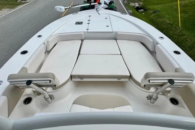 Slide: The Image of 2017 Robalo 246 Cayman boat with cushioned seating and rod holders on deck. - 13