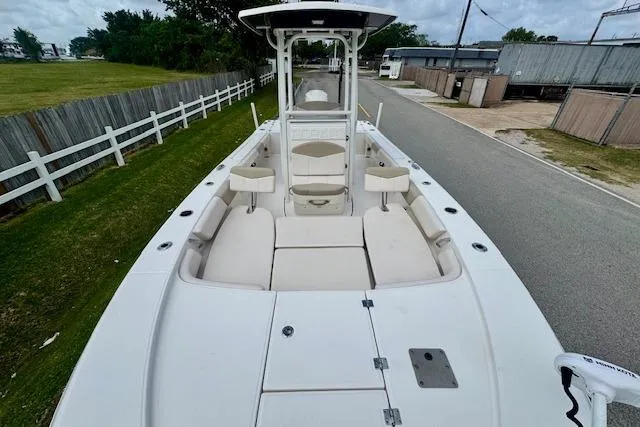 Slide: The Image of 2017 Robalo 246 Cayman boat with spacious deck and seating, parked on a roadside. - 16