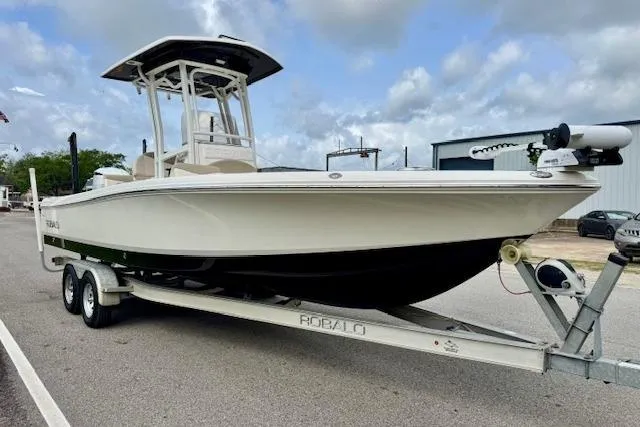 Slide: The Image of 2017 Robalo 246 Cayman boat on trailer, parked outdoors under cloudy sky. - 5