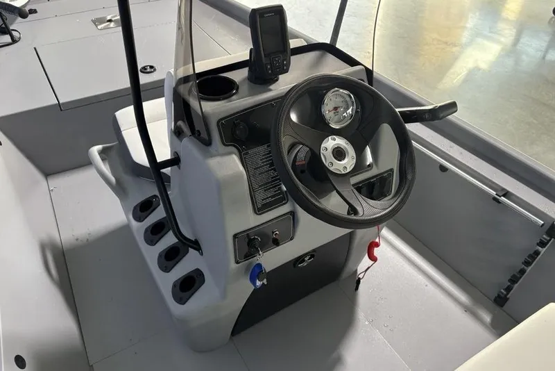 Slide: The Image of 2026 Tracker Bass Tracker Classic CC boat console with steering wheel and controls. - 14
