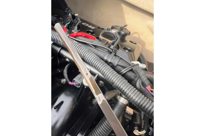 Slide: The Image of Engine compartment of a 2022 Sea-Doo FishPro Sport 170 with visible dipstick and wiring. - 13