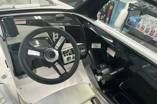 The Image of 2025 Yamaha Boats AR220 cockpit with steering wheel and control panel. - 1