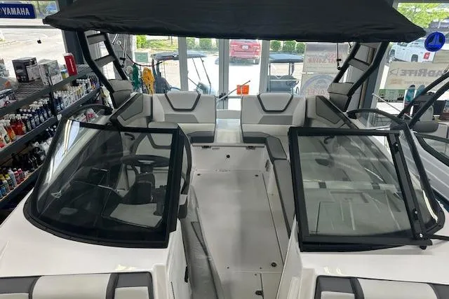 Slide: The Image of 2025 Yamaha Boats AR220 interior with seating and windshield, displayed in showroom. - 12