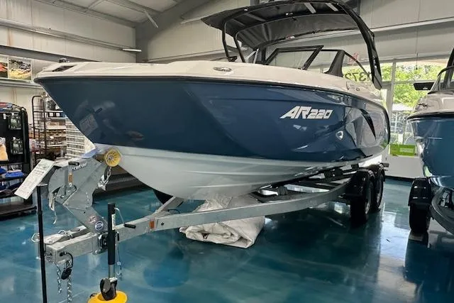 Slide: The Image of 2025 Yamaha Boats AR220 on trailer in showroom, blue and white design. - 4