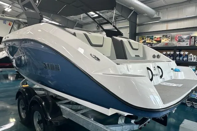 Slide: The Image of 2025 Yamaha Boats AR220 in showroom, sleek design, blue and white color scheme. - 5