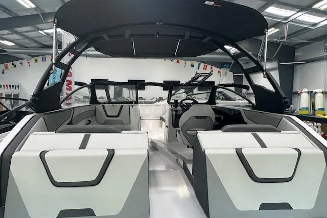 Slide: The Image of 2025 Yamaha Boats AR220 interior with sleek seating and modern design in a showroom. - 7
