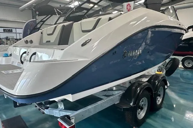 Slide: The Image of 2025 Yamaha Boats AR220 on trailer in showroom, featuring sleek design and blue hull. - 9