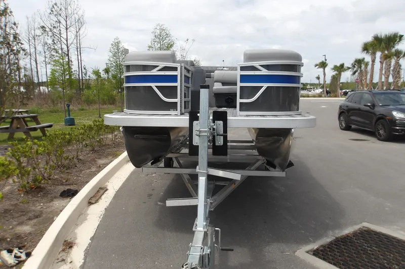 Slide: The Image of 2026 Bennington 16 S L-Bench pontoon boat on trailer, parked outdoors. - 3