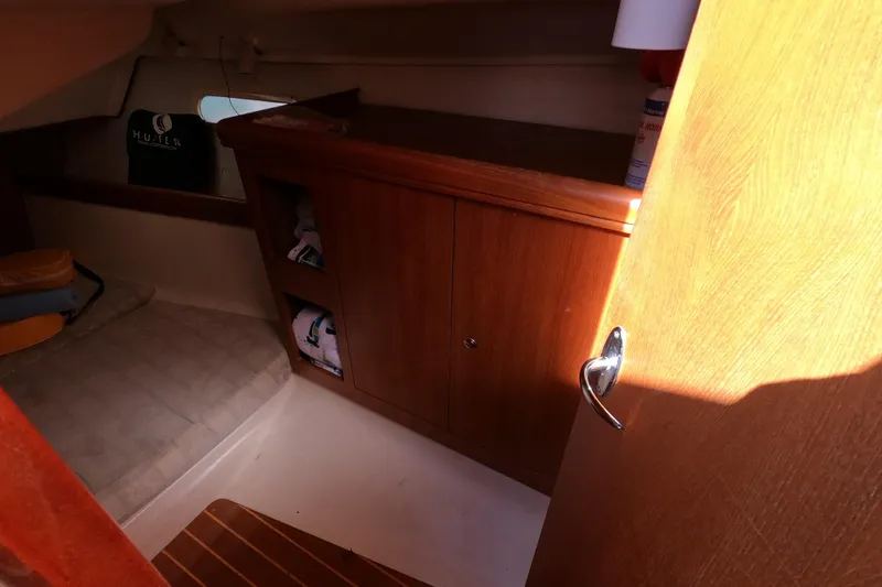 Slide: The Image of Interior cabin of 2003 Hunter 326 sailboat with wooden cabinetry and seating area. - 12