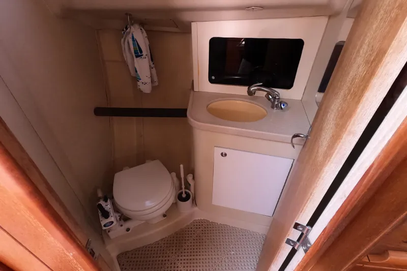 Slide: The Image of Compact bathroom in a 2003 Hunter 326 sailboat with toilet, sink, and storage. - 14
