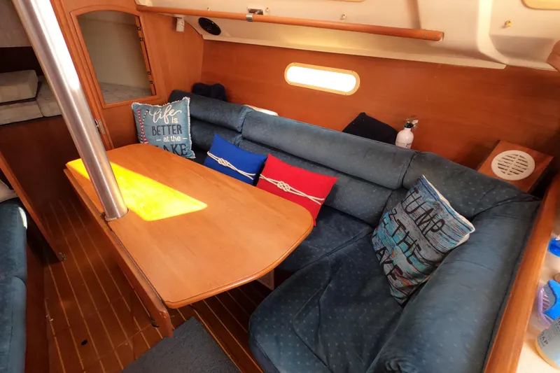 Slide: The Image of Cozy interior of 2003 Hunter 326 sailboat with blue cushions and decorative pillows. - 17
