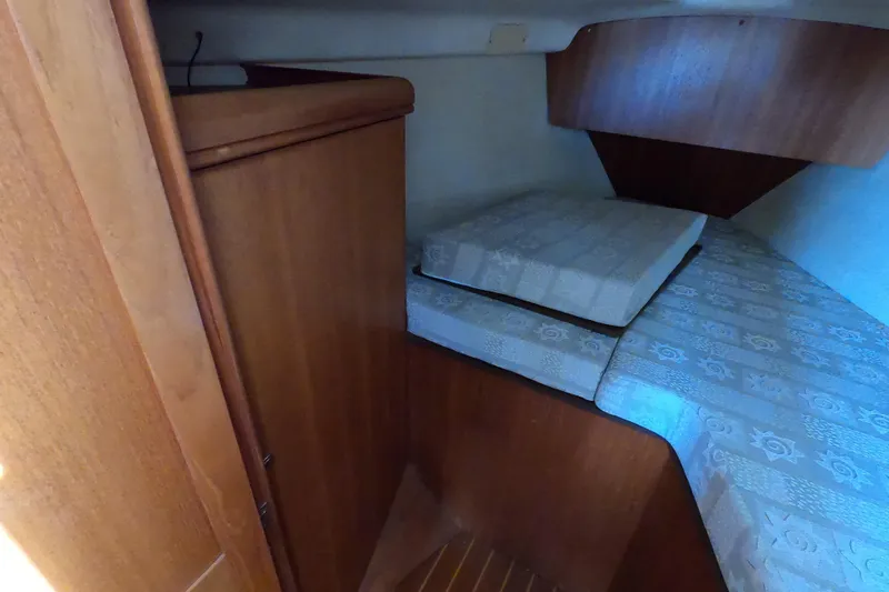 Slide: The Image of Interior cabin of 2003 Hunter 326 sailboat with wooden furnishings and bedding. - 20