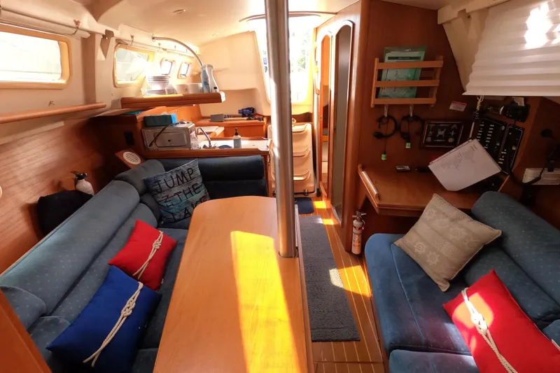 Slide: The Image of Interior of a 2003 Hunter 326 sailboat with cozy seating and nautical decor. - 21
