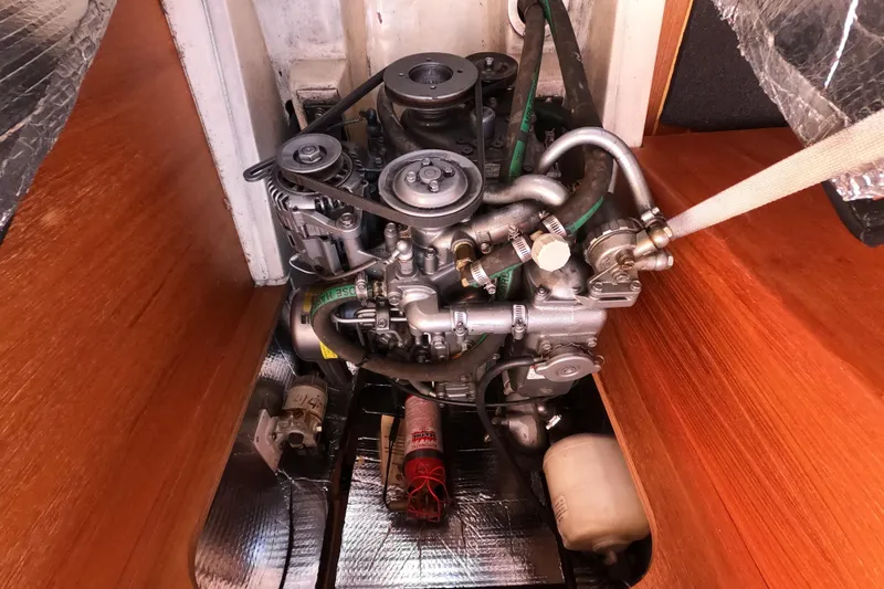 Slide: The Image of Engine compartment of a 2003 Hunter 326 sailboat, showcasing mechanical components and hoses. - 23