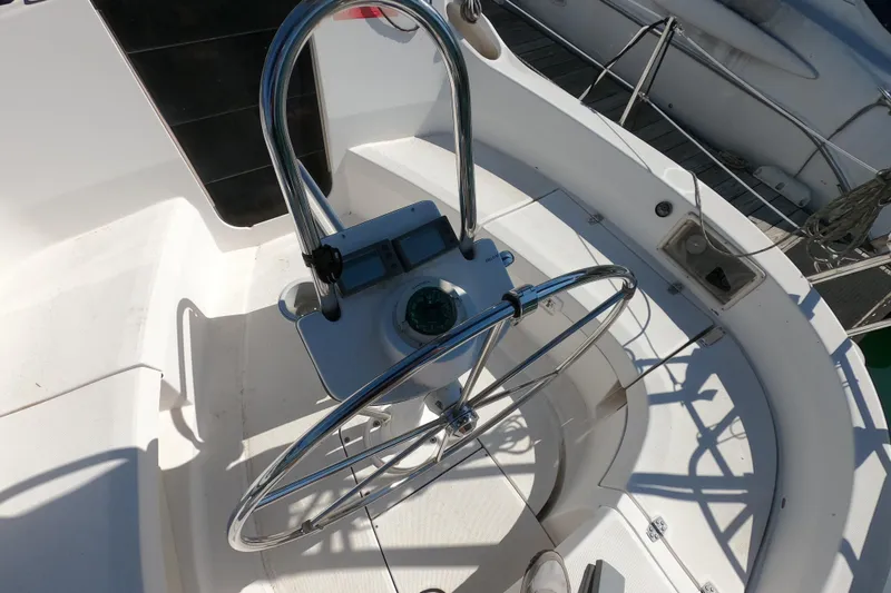 Slide: The Image of Steering wheel of a 2003 Hunter 326 sailboat, featuring a compass and navigation controls. - 8