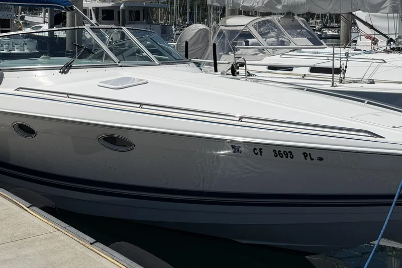 Slide: The Image of 2001 Formula 330 Sun Sport boat docked at a marina, showcasing sleek design and white exterior. - 2