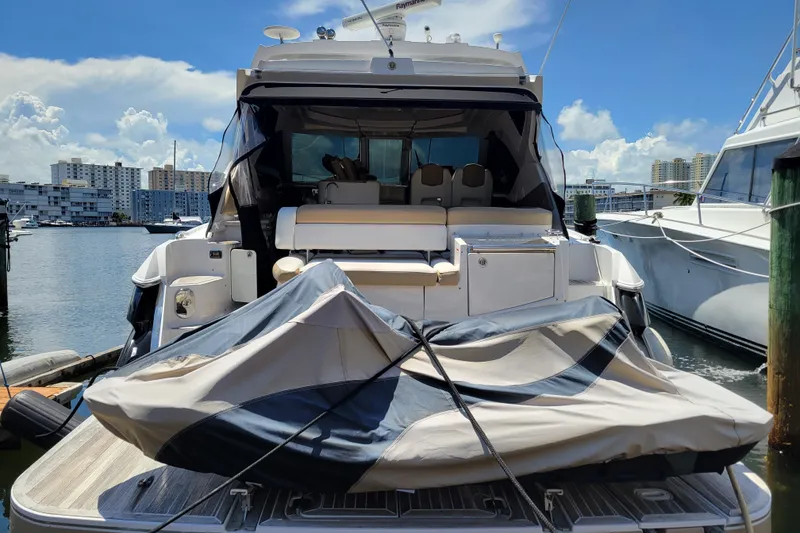 Slide: The Image of 2012 Four Winns V435 yacht docked, featuring spacious deck and covered seating area. - 35