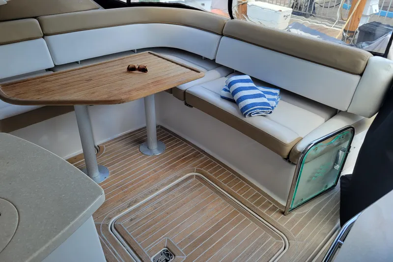 Slide: The Image of Interior of 2012 Four Winns V435 yacht with seating, table, and striped towel. - 49