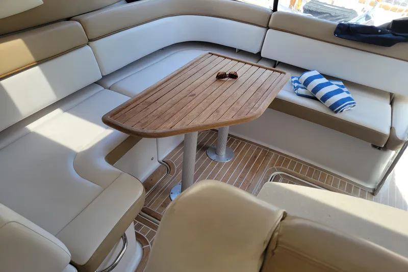 Slide: The Image of Luxurious seating area on 2012 Four Winns V435 yacht with wooden table and striped towel. - 52
