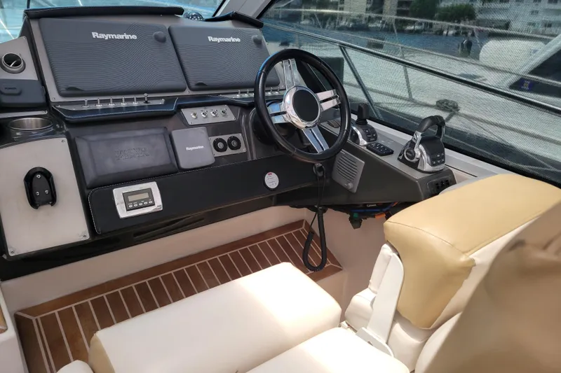 Slide: The Image of 2012 Four Winns V435 helm with Raymarine electronics and beige seating. - 57